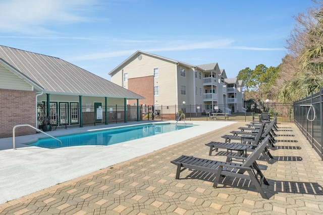 pool with a patio area and fence