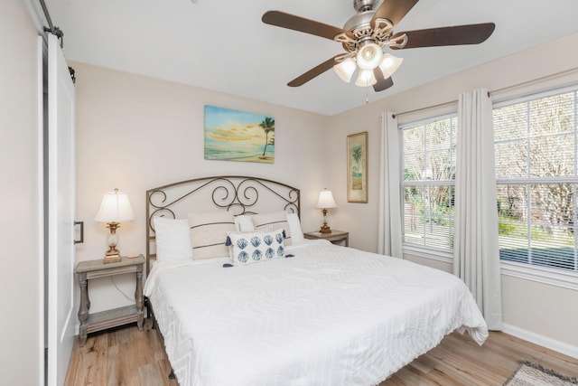 bedroom with light wood-type flooring, baseboards, and a ceiling fan