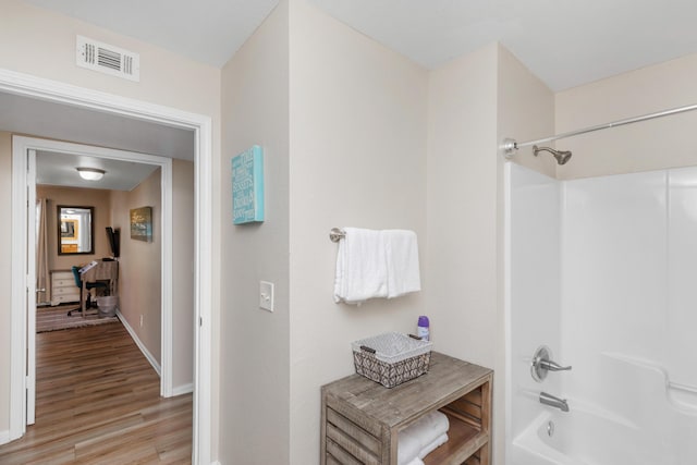 bathroom featuring  shower combination, visible vents, and wood finished floors