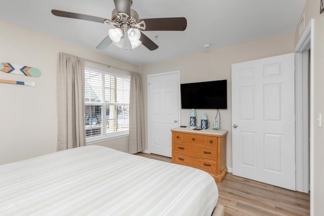 bedroom with a ceiling fan and light wood-style flooring