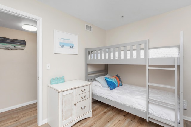 bedroom with visible vents, light wood-style flooring, and baseboards