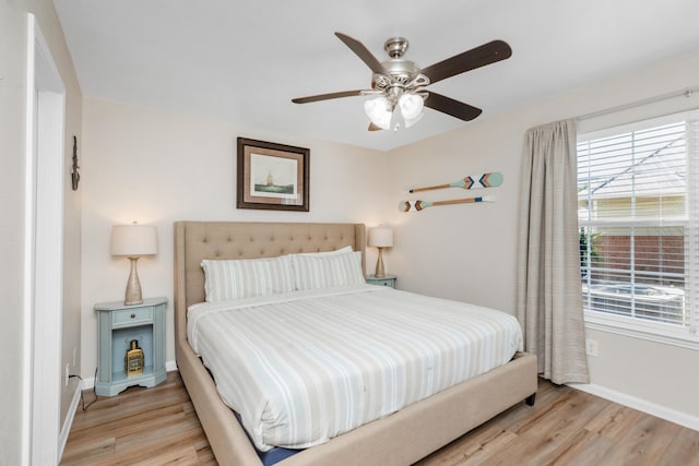 bedroom featuring light wood-type flooring, ceiling fan, and baseboards