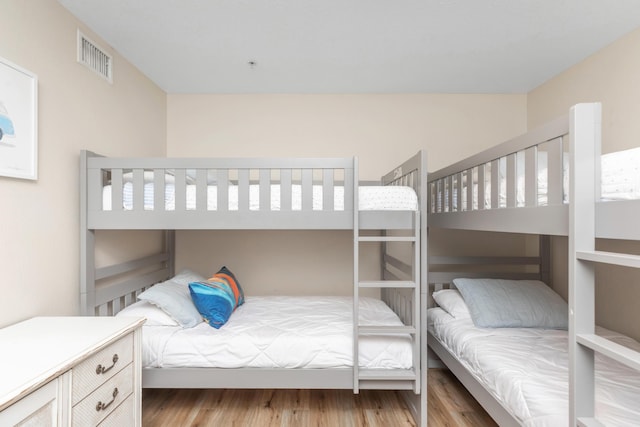 bedroom with light wood finished floors and visible vents