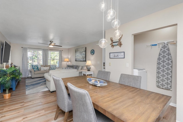 dining area with washer / clothes dryer, ceiling fan, and light wood finished floors