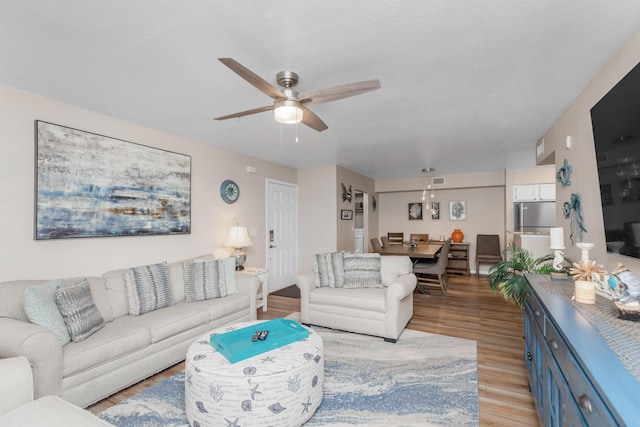 living room with light wood-style flooring and ceiling fan