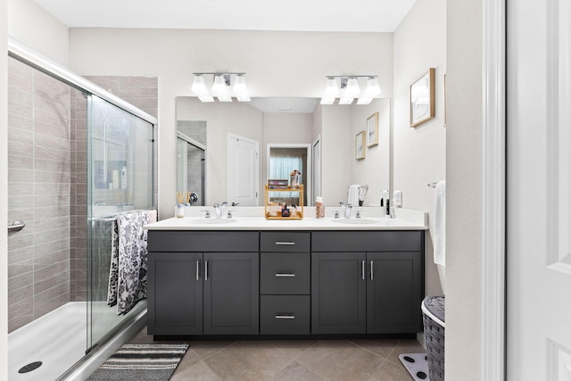 full bathroom with a stall shower, double vanity, a sink, and tile patterned floors