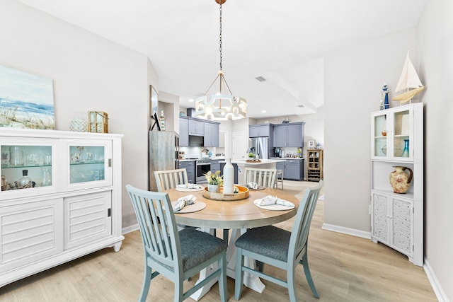 dining area featuring visible vents, a notable chandelier, light wood-style flooring, and baseboards