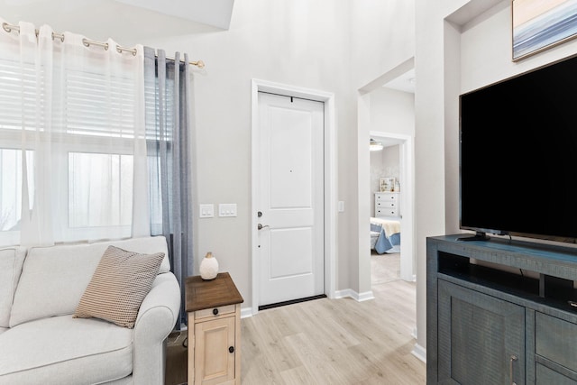 living area featuring light wood-style flooring and baseboards