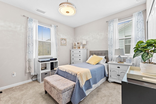 bedroom featuring visible vents, baseboards, and light colored carpet