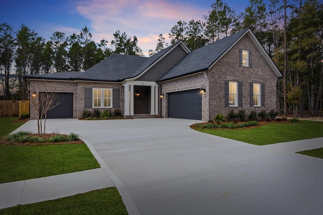 view of front of home featuring a garage, a front yard, and brick siding