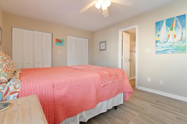 bedroom with ceiling fan, two closets, light wood-style flooring, and baseboards