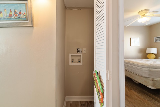 interior space featuring laundry area, baseboards, a ceiling fan, wood finished floors, and washer hookup