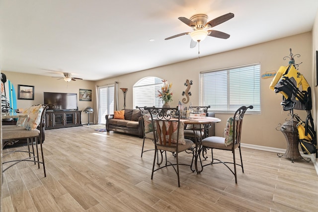 dining room with a ceiling fan, light wood-style flooring, and baseboards