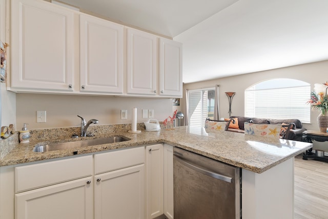 kitchen featuring a peninsula, a sink, white cabinetry, open floor plan, and dishwasher