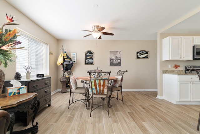 dining area with light wood-style floors, ceiling fan, and baseboards