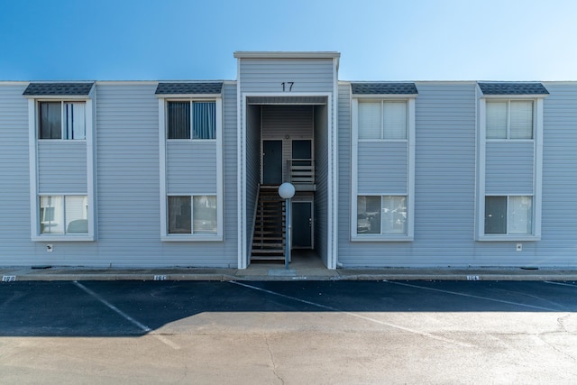 view of building exterior featuring stairs and uncovered parking