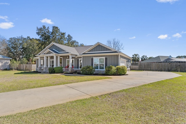 view of front of property with driveway, an attached garage, fence, a front lawn, and board and batten siding