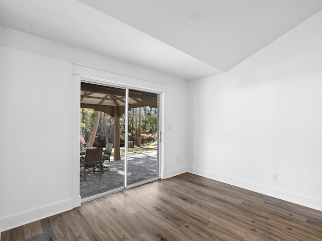 spare room with dark wood-style flooring and baseboards