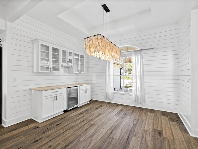 interior space featuring wine cooler, glass insert cabinets, dark wood-style flooring, hanging light fixtures, and white cabinetry