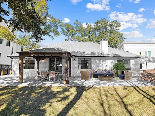 rear view of property featuring a patio area, a lawn, brick siding, and an outdoor hangout area