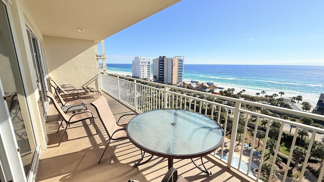 balcony with a water view and a view of the beach