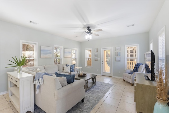 living area with light tile patterned flooring, visible vents, and baseboards