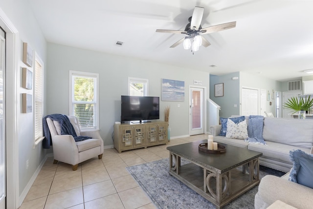 living area with light tile patterned floors, baseboards, visible vents, and a ceiling fan