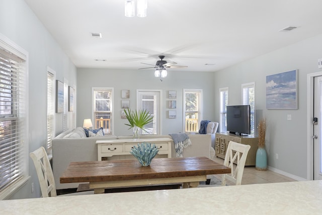 dining space featuring a ceiling fan, visible vents, baseboards, and light tile patterned flooring