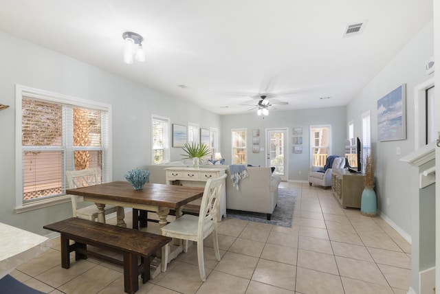 dining space featuring light tile patterned floors, a ceiling fan, visible vents, and baseboards