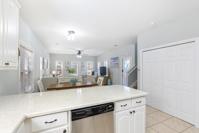 kitchen featuring white cabinetry, open floor plan, stainless steel dishwasher, and light countertops