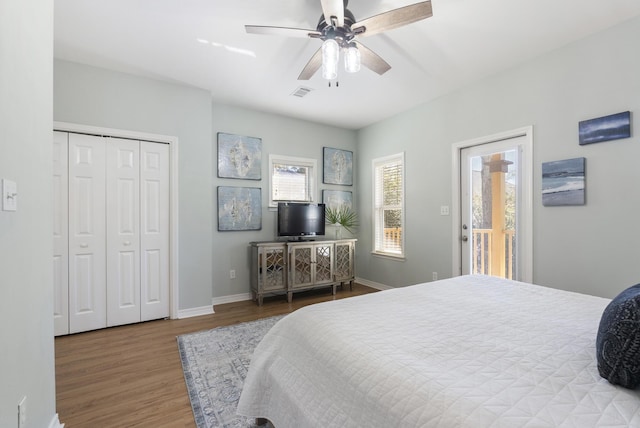 bedroom featuring visible vents, baseboards, ceiling fan, and wood finished floors