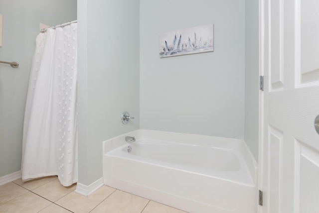 bathroom featuring a garden tub, tile patterned flooring, and baseboards