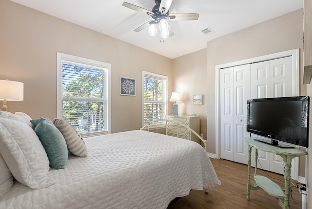 bedroom featuring baseboards, visible vents, ceiling fan, wood finished floors, and a closet