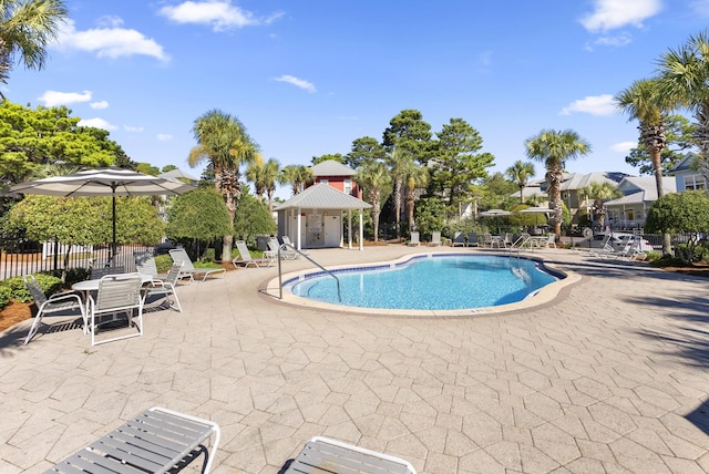 community pool featuring a gazebo, fence, and a patio