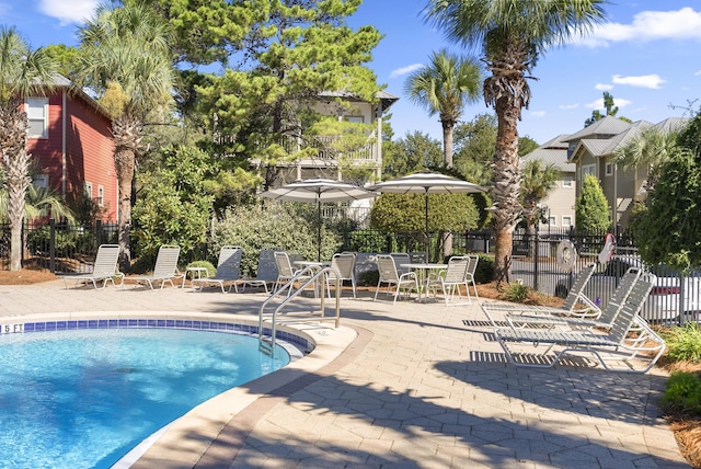 community pool with fence and a patio