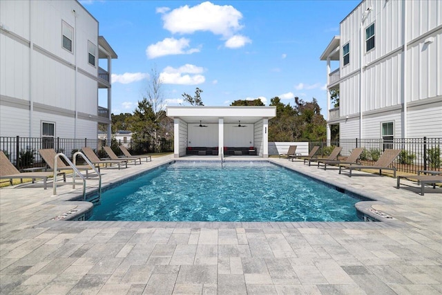 pool with a patio area, fence, and a ceiling fan