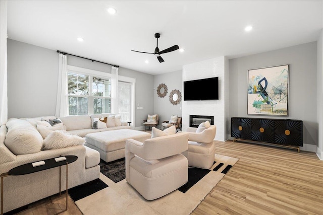 living area with ceiling fan, a fireplace, wood finished floors, and recessed lighting