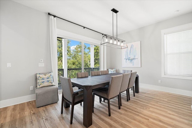 dining space with light wood finished floors and baseboards