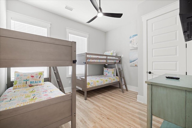 bedroom with light wood-style floors, baseboards, multiple windows, and visible vents