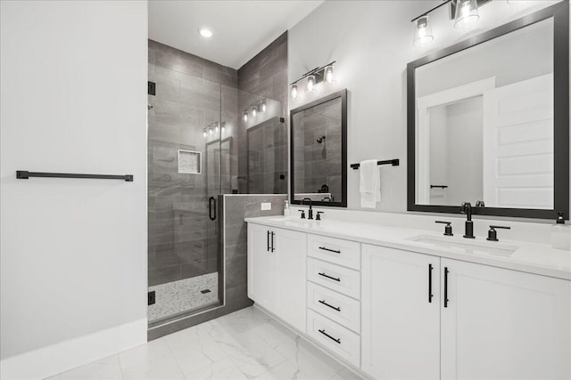 full bath with marble finish floor, double vanity, a sink, and a shower stall