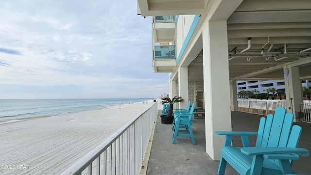 balcony featuring a water view and a beach view