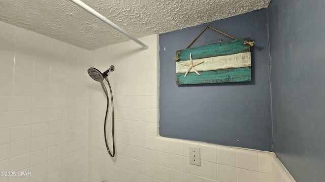 interior details featuring tiled shower and a textured ceiling