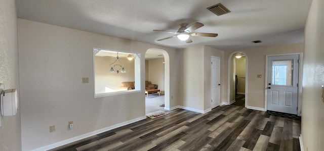 entryway with visible vents, arched walkways, and dark wood-type flooring