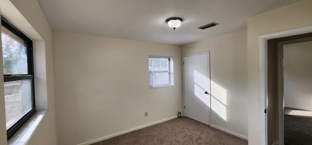 unfurnished bedroom with carpet, visible vents, and baseboards