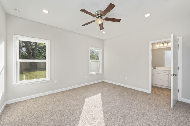 unfurnished bedroom featuring light carpet, baseboards, connected bathroom, and recessed lighting