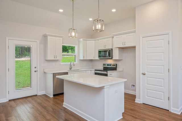 kitchen with a sink, light countertops, stainless steel appliances, white cabinetry, and dark wood-style floors