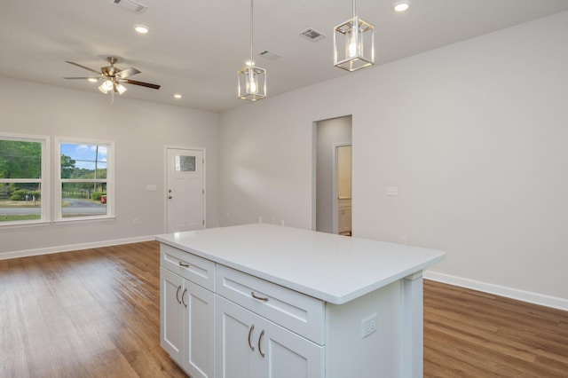 kitchen featuring light wood-type flooring, light countertops, visible vents, and hanging light fixtures