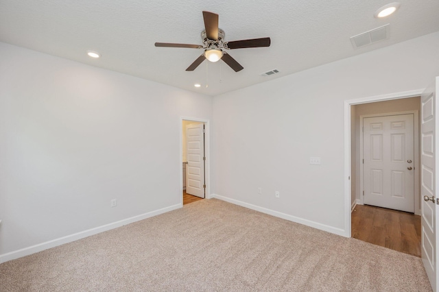 carpeted empty room featuring visible vents, a ceiling fan, and recessed lighting