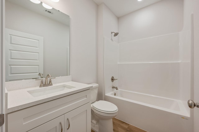 bathroom with washtub / shower combination, vanity, toilet, wood finished floors, and visible vents