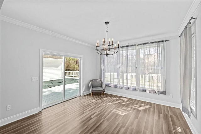 unfurnished dining area with crown molding, baseboards, and wood finished floors